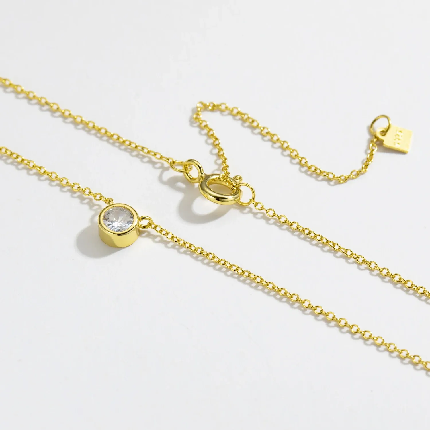 Деликатно сребърно колие с позлатен акцент и малък циркон